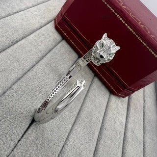 Cartier open-style cuff bracelet featuring a diamond-set panther head and spotted motif.